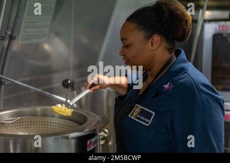 220219-N-FA490-1179 SAN BERNARDINO STRAIT (19 febbraio 2022) – Specialista culinario 2nd Class Crystal Wilkins, di Jackson, Mississippi, prepara la pasta nella cucina della nave litoranea da combattimento Independence-variante USS Jackson (LCS 6) durante le operazioni di routine. Allegato a Destroyer Squadron (DESRON) 7, Jackson è su uno schieramento rotazionale nell'area delle attività della flotta degli Stati Uniti 7th a sostegno della sicurezza e della stabilità nella regione, E lavorare insieme a navi alleate e partner per garantire la sicurezza e la stabilità marittima, pilastri chiave di un indo-Pacifico libero e aperto. Foto Stock