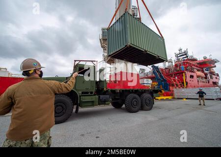 OKINAWA, Giappone (20 febbraio 2022) Equipment Operator 1st Classe Michael Nadeau, a sinistra, assegnato al Naval Mobile Construction Battalion (NMCB) 3, trasporta le apparecchiature negli Stati Uniti Picasso, nave di supporto subacquea contratta dalla Marina (DSCV) per sostenere il recupero dell'aeromobile F-35C Lightning II che si è schiantato durante le operazioni di volo di routine nel Mar Cinese Meridionale, gennaio 24. NMCB-3 è assegnato al comandante, Task Force (CTF) 75. CTF 75 e SUPSALV (Supervisore del salvataggio e delle immersioni) della NAVSEA stanno imbarcando Picasso per sorvegliare il recupero sicuro dell’aeromobile. Foto Stock