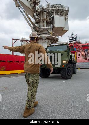 220220-N-QL471-0080 OKINAWA, Giappone (20 febbraio 2022) operatore dell'attrezzatura 1st Classe Michael Nadeau, assegnato al Battaglione Navale per la costruzione mobile (NMCB) 3, fornisce segnali al conducente del camion durante il trasporto dell'attrezzatura negli Stati Uniti Picasso, nave di supporto subacquea contratta dalla Marina (DSCV) per sostenere il recupero dell'aeromobile F-35C Lightning II che si è schiantato durante le operazioni di volo di routine nel Mar Cinese Meridionale, gennaio 24. NMCB-3 è assegnato al comandante, Task Force (CTF) 75. CTF 75 e SUPSALV (Supervisore del salvataggio e delle immersioni) della NAVSEA stanno imbarcando Picasso per sorvegliare il recupero sicuro dell'ai Foto Stock