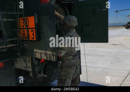 Green of Echo Troop, 7th Squadron, 17th Cavalry Regiment si prepara ad alimentare un AH-64E Apache alla Stefanovikeio Air base, Grecia, 21 febbraio 2022. Foto Stock