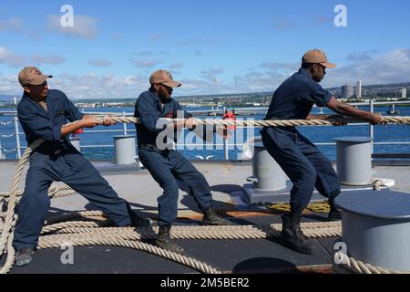 I marinai DI PEARL HARBOR, HAWAII (21 febbraio 2022) si aggirano intorno a una linea sul pivottolo della nave di sbarco anfibio di Harpers Ferry USS Pearl Harbor (LSD 52), mentre la nave parte da Pearl Harbor, Hawaii, 21 febbraio 2022. I marinai e i marines dell'Essex Amphhibious Ready Group (ARG) e della 11th Marine Expeditionary Unit (MEU) visitano Pearl Harbor, Hawaii, l'omonimo USS Pearl Harbor (LSD 52), mentre operano nella U.S. 3rd Fleet. Foto Stock