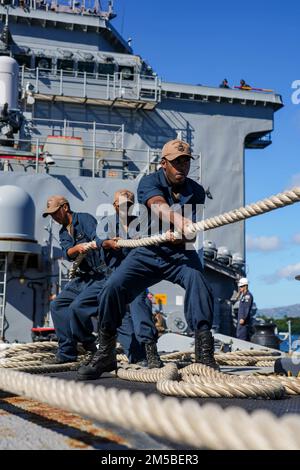 I marinai DI PEARL HARBOR, HAWAII (21 febbraio 2022) si aggirano intorno a una linea sul pivottolo della nave di sbarco anfibio di Harpers Ferry USS Pearl Harbor (LSD 52), mentre la nave parte da Pearl Harbor, Hawaii, 21 febbraio 2022. I marinai e i marines dell'Essex Amphhibious Ready Group (ARG) e della 11th Marine Expeditionary Unit (MEU) visitano Pearl Harbor, Hawaii, l'omonimo USS Pearl Harbor (LSD 52), mentre operano nella U.S. 3rd Fleet. Foto Stock