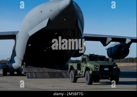 Durante l'esercizio fisico slimy Griffin presso Joint base McGuire-Dix-Lakehurst, New Jersey, 12-15 dicembre 2022, Un C-17 Globemaster III è caricato con un Joint Light Tactical Vehicle (JLTV) Utility. L'obiettivo del sottile Griffin è valutare la capacità, la capacità e la prontezza della forza totale per eseguire la missione di apertura della base aerea in un ambiente di guerra chimica simulato. (STATI UNITI Air Force foto di Senior Airman Faith Iris MacIlvaine) Foto Stock