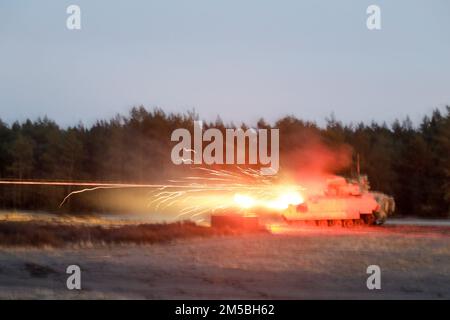 NEGLI STATI UNITI Army M2 Bradley veicolo da combattimento fanteria assegnato al 1st Squadron, 4th Cavalleria reggimento, 1st Armored Brigade Combat Team, 1st Fanteria Divisione spara la sua arma a Trzebien, Polonia, 22 febbraio 2022. Il 1-4 Cav ha condotto il tavolo da tiro Table V, che allena l'equipaggio di carri armati per impegnare bersagli stazionari e in movimento, posti in schiere tattiche, da un carro armato fisso e mobile con armi automatiche montate su carri armati sia di giorno che di notte. Foto Stock