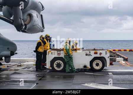 MARE DELLA CINA ORIENTALE (23 febbraio 2022) i marinai assegnati alla nave d'assalto anfibio USS America (LHA 6), schierata a termine, si preparano a individuare un velivolo tiltrotor MV-22B Osprey dell'unità di spedizione marina (MEU) 31st sul ponte di volo della nave. L'America, nave guida dell'America Amphibious Ready Group, insieme al 31st MEU, opera nell'area di responsabilità della flotta degli Stati Uniti 7th per migliorare l'interoperabilità con alleati e partner e fungere da pronta forza di risposta per difendere la pace e la stabilità nella regione dell'Indo-Pacifico. Foto Stock