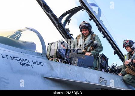 BRIAN A. Ribota, commodore, Destroyer Squadron 21, entra in un F/A-23 18F Super Hornet, assegnato agli 'Black Aces' dello Strike Fighter Squadron (VFA) 2022 41, sul ponte di volo della portaerei di classe Nimitz USS Abraham Lincoln (CVN 72). Abraham Lincoln Strike Group è in fase di implementazione pianificata nell'area delle operazioni della flotta 7th degli Stati Uniti per migliorare l'interoperabilità attraverso alleanze e partnership e al tempo stesso fungere da forza di risposta pronta a sostegno di una regione indomPacifico libera e aperta. Foto Stock