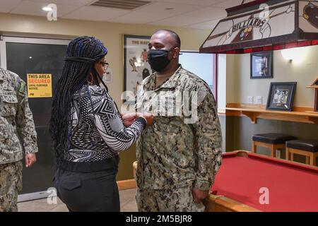 Dallas, Texas, ingineman Senior Chief Petty Officer Dirke D. Harper, assegnato al dipartimento di gestione delle emergenze Joint Expeditionary base Little Creek-Fort Story, è fissato da sua moglie, Julia, in una cerimonia di frocking tenutasi a bordo di JEBLCFS il 23 febbraio 2022. Foto Stock