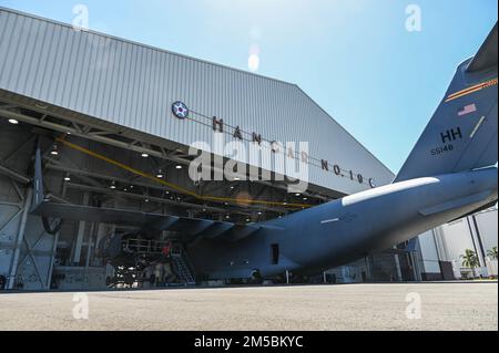 Un C-17 Globemaster III subisce un cambio di motore in Hangar 19 su base congiunta Pearl Harbor-Hickam, Hawaii, 23 febbraio 2022. Gli aerei assegnati al 15th Maintenance Group e alla Hawaii Air National Guard hanno scollegato tutti gli attacchi di un motore turbofan dall'aeromobile da carico per essere sostituiti e ricondizionati. Foto Stock