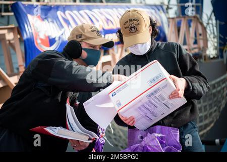 FLEET ACTIVITIES YOKOSUKA, Giappone (24 febbraio 2022) Logistics Specialist 2nd Class Joshua Lyons, a sinistra, da Pangburn, Arkansas, E Logistics Specialist 3rd Class Alexandra Adams, di Longview, Texas, smistare la posta sul molo mentre il cacciatorpediniere missilistico guidato di Arleigh Burke-class USS Dewey (DDG 105) fa una sosta logistica a Fleet Activities Yokosuka, Giappone. Dewey è assegnato al CTF 71/Destroyer Squadron (DESRON) 15, il più grande DESRON della Marina e la principale forza di superficie della flotta statunitense 7th. Foto Stock