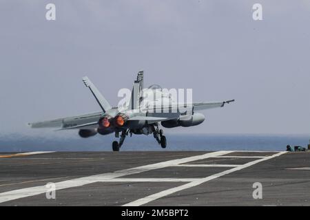 MARE DELLE FILIPPINE (24 febbraio 2022) un F/A-18E Super Hornet, assegnato ai 'Tophatters' di Strike Fighter Squadron (VFA) 14, lancia dal ponte di volo della portaerei di classe Nimitz USS Abraham Lincoln (CVN 72). Abraham Lincoln Strike Group è in fase di implementazione pianificata nell'area delle operazioni della flotta 7th degli Stati Uniti per migliorare l'interoperabilità attraverso alleanze e partnership e al tempo stesso fungere da forza di risposta pronta a sostegno di una regione indomPacifico libera e aperta. Foto Stock