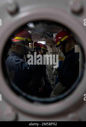 GOLFO DI OMAN (24 febbraio 2022) marinai assegnati al cacciatorpediniere missilistico guidato USS Gridley (DDG 101), si preparano a combattere un incidente alluvione durante un'esercitazione di controllo dei danni nel Golfo di Oman, 24 febbraio. Gridley è schierato nell'area delle operazioni della flotta degli Stati Uniti 5th a sostegno delle operazioni navali per assicurare la stabilità e la sicurezza marittima nella regione centrale, collegando il Mediterraneo e il Pacifico attraverso l'Oceano Indiano occidentale e tre punti di arresto strategici. Foto Stock