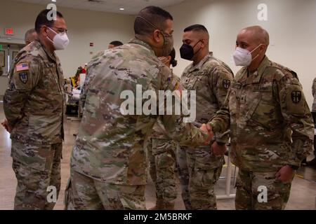 Il generale John C. Andonie, vicedirettore della Guardia Nazionale dell'Esercito, saluta SPC. Danny Capacetti, dopo avergli dato una moneta di eccellenza per essersi levato in piedi fuori nei suoi compiti a Fort Buchanan, Porto Rico, 24 febbraio 2022. Capacetti è riuscito a integrare e a riflettere la sua leadership prendendo il tempo di insegnare, guidare e aiutare gli altri con un atteggiamento positivo e motivazionale che abbraccia l'intero spazio di lavoro. Foto Stock