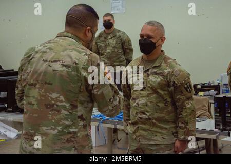 Jonathan Santiago, si trova nella posizione di attenzione davanti al maggiore Gen. John C. Andonie, vicedirettore della Guardia Nazionale dell'Esercito, per ricevere una moneta di eccellenza per essersi levato in piedi nei suoi compiti a Fort Buchanan, Porto Rico, 24 febbraio 2022. Il vicedirettore della Guardia Nazionale dell'Esercito visitò l'isola e riconobbe questi soldati con una moneta di eccellenza per essersi levato in piedi nei suoi doveri durante gli sforzi contro il COVID-19. Foto Stock