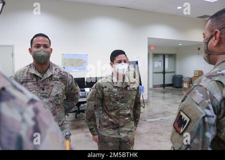 SPC. Zuleyka Cruz, in piedi nella posizione di attenzione di fronte al Gen. Maggiore John C. Andonie, vicedirettore della Guardia Nazionale dell'Esercito, per ricevere una moneta di eccellenza per essere stato in piedi fuori nei suoi compiti come polizia militare della Guardia Nazionale di Porto Rico a Fort Buchanan, Porto Rico, 24 febbraio 2022. SPC. Zuleyka Cruz è una polizia militare che ha svolto e realizzato al meglio la sua abilità con la sua eccellente leadership, le sue capacità professionali e i suoi incessanti sforzi. Foto Stock