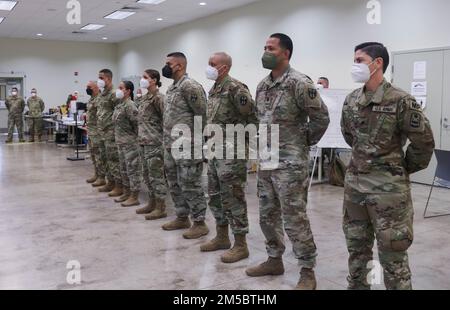 I soldati della Joint Task Force - Porto Rico si trovano a proprio agio dopo essere stati selezionati per ricevere una moneta di eccellenza dal Major Gen. John C. Andonie, vicedirettore della Guardia Nazionale dell'Esercito, a Fort Buchanan, Porto Rico, 24 febbraio 2022. Il vicedirettore della Guardia Nazionale dell'Esercito visitò l'isola e riconobbe questi soldati con una moneta di eccellenza per essersi levato in piedi nei suoi doveri durante gli sforzi contro il COVID-19. Foto Stock