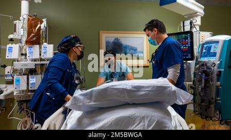 YUMA, Ariz. -- STATI UNITI Michael Burnett, centro, un assistente medico di 75th operazione Medical Readiness Squadron, Hill Air Force base, lavora con Jasmine Mendez, a sinistra, E Christian Flores, di destra, infermieri residenti unità di terapia intensiva lavorano insieme per spostare un paziente nel loro letto presso lo Yuma Regional Medical Center di Yuma, Arizona, il 24 febbraio 2022. Gli Stati Uniti I militari vengono impiegati a supporto delle continue operazioni di risposta COVID del Dipartimento della Difesa per aiutare le comunità in stato di necessità. STATI UNITI Northern Command, attraverso gli Stati Uniti Army North, rimane impegnata a fornire Dipartimento flessibile di Foto Stock