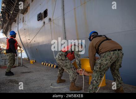 Marinai assegnati al comandante, attività della flotta Sasebo (CFAS) gestisce le linee come la nave d'assalto anfibio USS America (LHA 6) ormeggia a pierside al CFAS 25 febbraio 2022. Per 75 anni, CFAS ha fornito, mantenuto e gestito strutture e servizi di base per potenziare le forze alleate e statunitensi schierate in futuro, fornendo al contempo un supporto superiore alle loro famiglie e alla comunità. Foto Stock