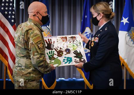 STATI UNITI Air Force Brig. Il generale Daniel Gabrielli, comandante della Task Force Holloman, presenta un dipinto realizzato da bambini afghani con l'operazione Alleati Benvenuti al Major Gen. Dawne Deskins, vicedirettore, Air National Guard, durante la cerimonia di ritiro presso la Joint base Anacostia-Bolling, District of Columbia, 25 febbraio 2022. Deskins incontrò i bambini mentre visitava un'installazione militare che supportava OAW. Foto Stock