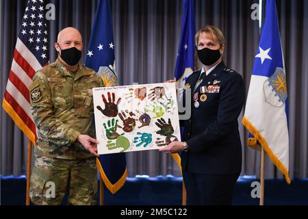 STATI UNITI Air Force Brig. Il generale Daniel Gabrielli, comandante della Task Force Holloman, presenta un dipinto realizzato da bambini afghani con l'operazione Alleati Benvenuti al Major Gen. Dawne Deskins, vicedirettore, Air National Guard, durante la cerimonia di ritiro presso la Joint base Anacostia-Bolling, District of Columbia, 25 febbraio 2022. Deskins incontrò i bambini mentre visitava un'installazione militare che supportava OAW. Foto Stock