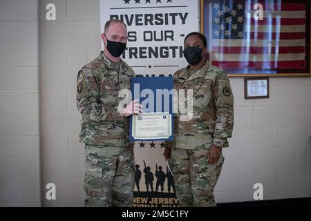 STATI UNITI Bill Morris, a sinistra, capo di stato maggiore, New Jersey Army National Guard presenta Sgt. 1st Classe Quintessa Nash con un certificato di apprezzamento durante un mese di storia nera osservanza su base congiunta McGuire-Dix-Lakehurst, New Jersey, 25 febbraio 2022. Nash ha parlato delle sue esperienze come match e donatore di midollo osseo. Foto Stock