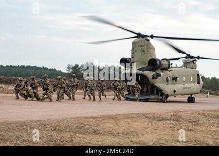 STATI UNITI I paracadutisti di 3rd Brigade Combat Team, 82nd Airborne Division escono da un CH-47 Chinook durante una dimostrazione di assalto aereo a Nowa Deba, Polonia, 25 febbraio 2022. L'obiettivo della missione della 82nd Airborne Division è quello di assicurare i nostri alleati fornendo una serie di capacità uniche e conducendo un'ampia gamma di missioni scalabili e adattabili alle esigenze della missione. Foto Stock