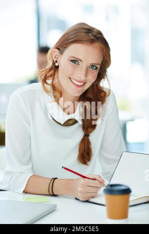 Lavorare sodo per superare le aspettative. Ritratto di una giovane donna d'affari che lavora in un ufficio. Foto Stock