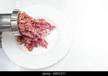 Carne di maiale macinata, carne macinata e un macinacaffè di metallo, primo piano morbido Foto Stock