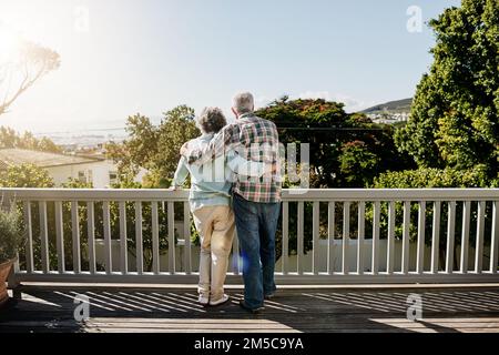 E così comincia la pensione. Ripresa da dietro di una coppia anziana che abbraccia l'esterno sul balcone. Foto Stock