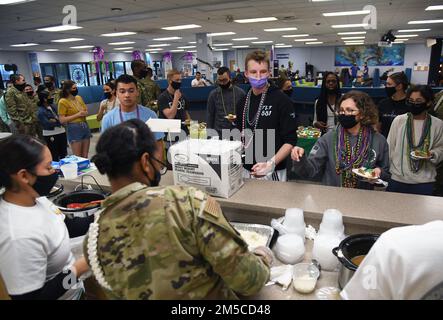 Gli airmen del 81st Training Group stand in linea per i campioni di gumbo all'interno del Loritow Training Support Facility alla Keesler Air Force base, Mississippi, 1 marzo 2022. L'evento, ospitato dall'ufficio cappellani della Training Wing 81st, è stato in celebrazione del Mardi Gras e ha anche fornito fette di torta reale. Foto Stock