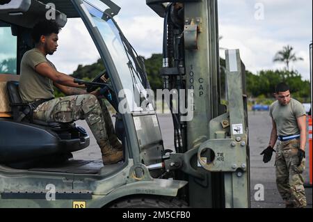 Airman 1st Class Justin Marcano e Airman 1st Class Jaylen Alberts, 647th Logistics Readiness Squadron trasporto a terra viaggianti, comunicare mentre manovrare 15th manutenzione Gruppo attrezzatura durante l'esercizio TROPIC FURY alla base comune Pearl Harbor-Hickam, Hawaii, 1 marzo 2022. La capacità di 15th Wing di preparare gli Airmen e gli aeromobili per le operazioni di sollevamento aereo è stata testata durante l’esercizio. Foto Stock