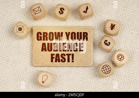 Concetto aziendale. Sul tessuto ci sono cubi con disegni e un segno con l'iscrizione - FAR CRESCERE IL PUBBLICO VELOCEMENTE Foto Stock