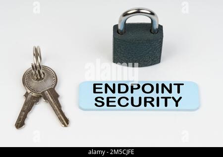 Il concetto di sicurezza nelle imprese. Su una superficie bianca c'è una serratura, chiavi e un segno blu con l'iscrizione - sicurezza endpoint Foto Stock