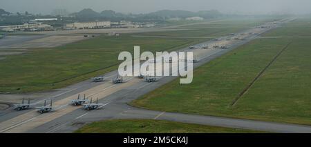 Una formazione di F-15C/D Eagles assegnata ai 44th e 67th Fighter Squadron, un KC-135 Stratotanker assegnato al 909th Air Refuelling Squadron, e un e-3 Sentry assegnato al 961st Airborne Air Control Squadron taxi durante un esercizio di routine di preparazione ala alla base aerea di Kadena, Giappone, 2 marzo 2022. La formazione rappresenta il culmine degli sforzi dedicati dell'intera 18th Wing, con ogni membro che fornisce contributi vitali per garantire che il Team Kadena sia pronto a fornire airpower in qualsiasi momento e ovunque. Foto Stock