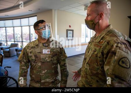 Brig. Il generale Darwin Craig, direttore della Guardia Nazionale dello Utah, ha parlato con il PFC. David Bravo, membro della COVID-19 Joint Task Force, della sua esperienza presso la Southern Utah Veterans Home a Ivins, Utah, il 2 marzo 2022. Alla luce delle recenti carenze di personale sanitario, Craig è stato accolto con gratitudine e osservazioni illuminanti da parte dei membri del consiglio di amministrazione e del personale per quanto riguarda il sostegno dei membri della Guardia Nazionale dello Utah della Joint Task Force COVID-19 mentre visitava le strutture sanitarie di St George. Foto Stock