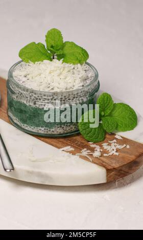delizioso budino di cocco vegano chia con menta, su tavolo bianco Foto Stock