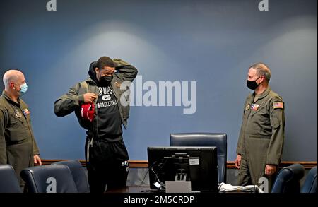 Keldon Johnson, un giocatore di basket di San Antonio Spurs, indossa una giacca di volo dell'aeronautica militare durante una visita alla 433rd Airlift Wing presso la Joint base di San Antonio-Lackland, Texas, 2 marzo 2022. Terry McClain, 433rd° comandante AW (a destra), e il col. James Miller, 433rd° comandante del gruppo operativo (a sinistra), diede a Johnson la giacca per accoglierlo nell'ala. Foto Stock