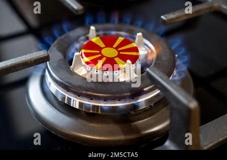 Concetto di importazione ed esportazione di gas. Un bruciatore a gas di una stufa domestica, al centro della quale è raffigurata una bandiera - Macedonia Foto Stock