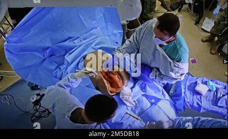 Christopher Bell (in alto a destra), chirurgo generale, William Beaumont Army Medical Center, insieme a un Soldato dal 745th rianimazione in avanti distaccamento chirurgico condotto uno scenario operativo utilizzando un manichino di simulazione medica il 3 marzo 2022 presso la sala operatoria del Centro Simulazione. (Foto di Vincent Byrd, WBAMC PAO) Foto Stock