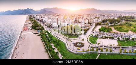 Veduta aerea di un tramonto sul parco della spiaggia con i vacanzieri in Antalya, Turkiye. Mar Mediterraneo costa e riviera. Foto Stock