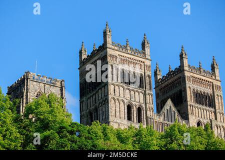 Durham Inghilterra: 2022-06-07: Esterno della cattedrale di Durham durante le giornate estive soleggiate con alberi verdi lussureggianti e cielo blu. Vista in primo piano Foto Stock