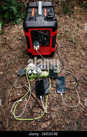 Stazione di ricarica portatile con telefoni cellulari in natura, la stazione di ricarica portatile è rispettosa dell'ambiente. Foto Stock