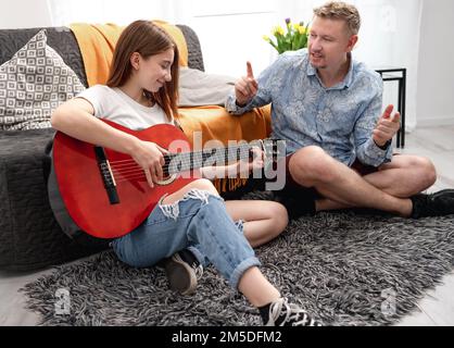 Ragazza adolescente che pratica la chitarra Foto Stock