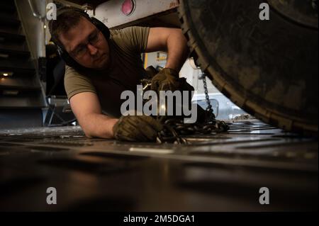 STATI UNITI Air Force Senior Airman Christian Shank, 621st Contingency Response Squadron aereo porter, assicura un rimorchio al pavimento di un C-17 Globemaster III, 4 marzo 2022, a Hunter Army Airfield, Georgia. Gli aerei assegnati al 621st CRS, 321st CRS e 621st Mobility Support Operations Squadron integrati con i soldati assegnati alla 3rd Divisione Fanteria e Arrival Departure Airfield Control Group per il trattamento di carichi, attrezzature e personale per un rapido spiegamento. Foto Stock