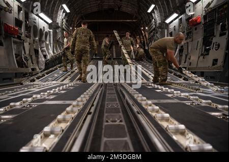 STATI UNITI Air Force Airmen assegnato al 621st Contingency Response Wing, installare rulli di carico su un C-17 Globemaster III, 4 marzo 2022, presso l'Hunter Army Airfield, Georgia. Gli aerei assegnati al 621st CRS, 321st CRS e 621st Mobility Support Operations Squadron integrati con i soldati assegnati alla 3rd Divisione Fanteria e Arrival Departure Airfield Control Group per il trattamento di carichi, attrezzature e personale per un rapido spiegamento. Foto Stock