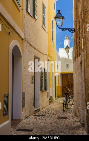 Una bicicletta in una stretta strada acciottolata nell'antica capitale di Ciutadella, Minorca, Spagna Foto Stock