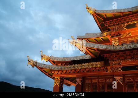 Tetto del tempio cinese sullo sfondo del cielo. Tetto tradizionale cinese con dettagli arancioni e ornamenti dorati. Tetto di colore arancione sul tempio di Shangri-l Foto Stock