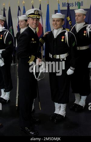 220304-N-ZZ000-1003 (4 marzo 2022) Airman Marco Ruiz, a destra, riceve la sua aiguillette da CMdR. Dave Tickle, ufficiale comandante degli Stati Uniti Guardia Ceremoniale della Marina, durante una cerimonia di laurea a bordo della base comune Anacostia-Bolling Marzo 4. Questi marinai sono stati selezionati a mano dal comando di addestramento del reclutamento durante il loro addestramento di base, basato su un processo di intervista e sui requisiti fisici, per rappresentare il servizio navale nelle cerimonie presidenziali, militari, della marina e pubbliche dentro e intorno a Washington D.C. Foto Stock