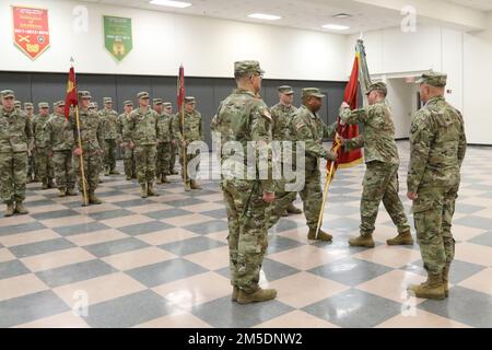 Il comando Sgt. Maj. Remy Santi, comandante Sergente maggiore della 228th Transportation Company, passa il battaglione guidon al Lt. David Marous, comandante uscente dell'unità, durante una cerimonia di cambio di comando a Fort Indiantown Gap, Annville, Pa. Marzo 5, 2022. Foto Stock