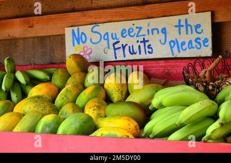 Un proprietario di piccola impresa fa una richiesta educata e divertente per quelli che acquistano la frutta fresca al carrello dell'alimento in Hawaii Foto Stock
