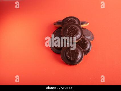 foto di un gruppo di biscotti ricoperti di cioccolato accanto a su sfondo viola su sfondo viola Foto Stock